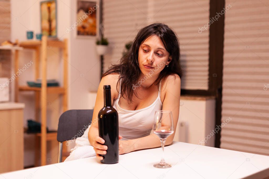 Alcoholic woman holding bottle of wine