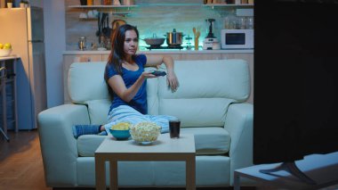 Ev hanımı televizyon kanallarını değiştiriyor.