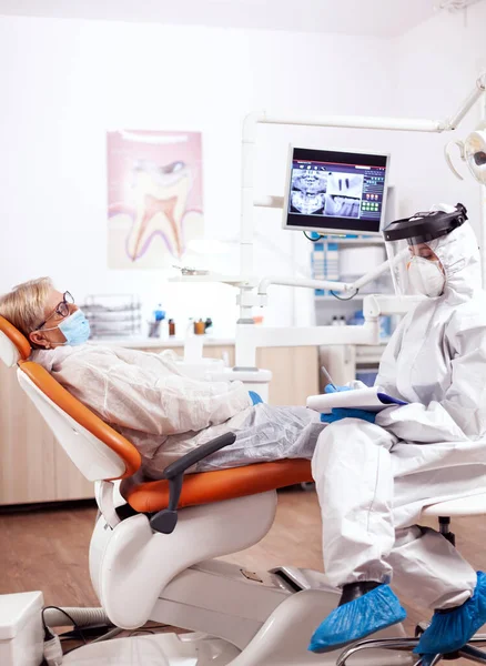 Ассистент стоматолога в защитном костюме против коронавируса — стоковое фото