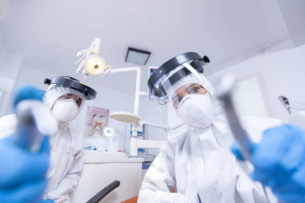 Стоматологическая команда склоняется над пациентом для работы с деснами пациентов — стоковое фото
