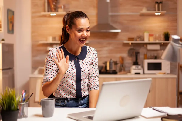 Woman waving during video conference