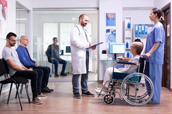 Medic talking with disabled woman in hospital