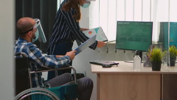 Współpracownicy z maskami i niepełnosprawnością pracujący w nowym normalnym biurze — Wideo stockowe
