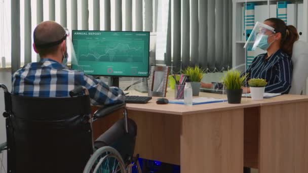 Pracownik finansowy na wózku inwalidzkim przestrzegający odległości społecznej — Wideo stockowe