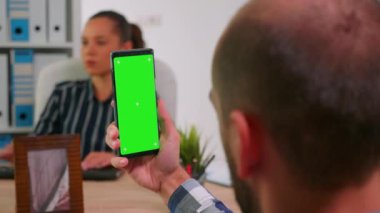 Tekerlekli sandalyede yeşil ekran akıllı telefon kullanan bir yönetici