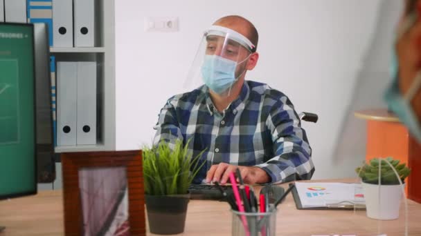 Handicapped woker with protection mask discussing with colleague — Stock Video