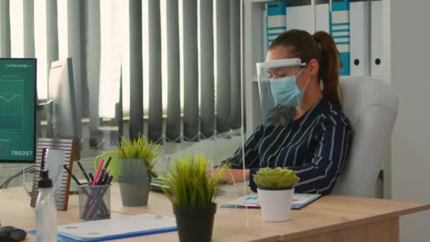 新しい通常のオフィスで働く保護マスクを持つマネージャー — ストック動画