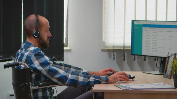 Gehandicapten die in een rolstoel zitten en telemarketing maken — Stockvideo