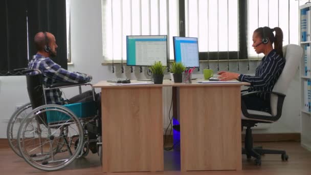 坐轮椅的男子使用耳机进行电话推销 — 图库视频影像