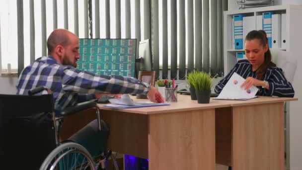 Бизнесмен в инвалидной коляске работает в корпоративном офисе — стоковое видео