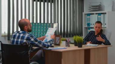 Engelli iş arkadaşıyla konuşan kadın istatistikleri analiz ediyor