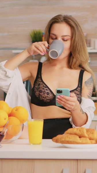 Sexy hospodyňka pomocí chytrého telefonu — Stock fotografie