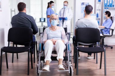 Tekerlekli sandalyede oturan sakat yaşlı kadın