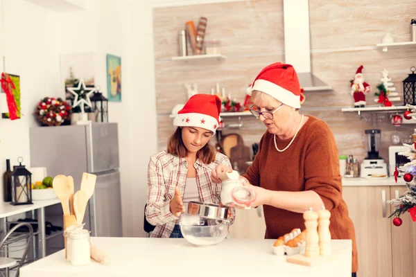 Großmutter lernt Nichte zu Weihnachten leckere Plätzchen backen. — Stockfoto