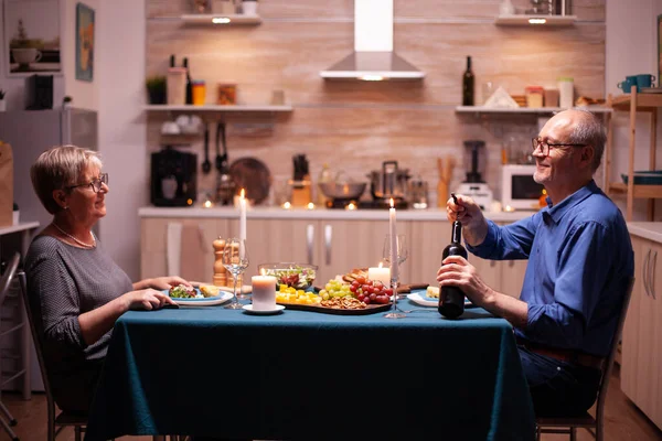 Älterer Mann öffnet eine Flasche Wein — Stockfoto