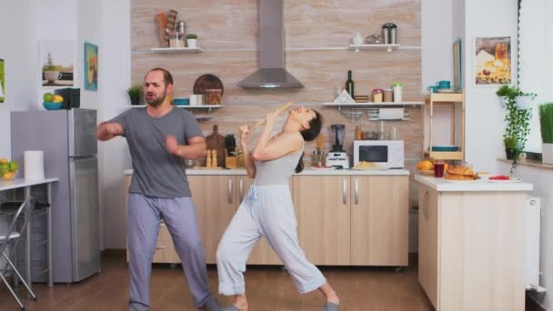 Забавная пара танцует на кухне — стоковое видео