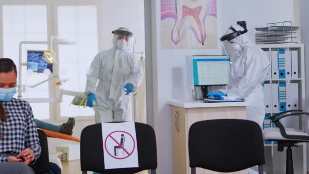 Médico dental con traje ppe sosteniendo los dientes de rayos X — Vídeo de stock