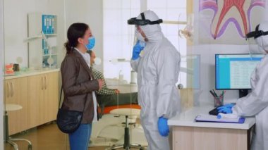 Hastaya diş tedavisini açıklayan diş hekimi.