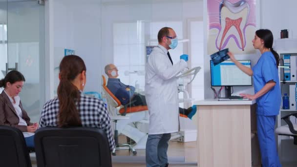 치과 의사가 치과 방사선 검사를 해 달라고 간호사에게 요청하는 모습 — 비디오