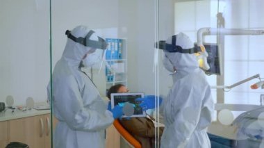 Diş hekimleri diş röntgenini açıklayan tablet kullanıyorlar.