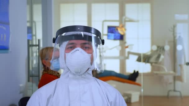 Retrato del médico exhausto en el consultorio dental mirando a la cámara — Vídeos de Stock