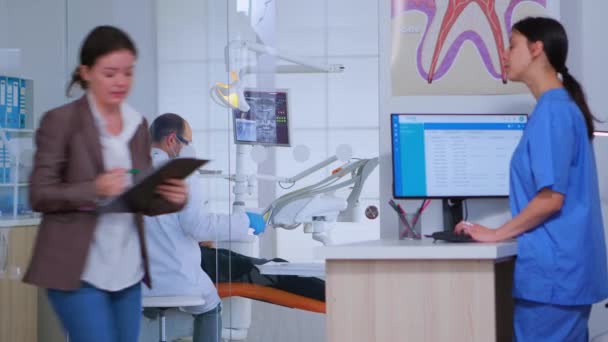Pacientes que piden ayuda para rellenar el formulario de registro dental — Vídeos de Stock
