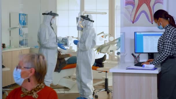 Lékaři v uniformě plné ochrany proti virům mluví v chirurgickém sále — Stock video