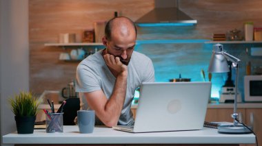 İşadamı dizüstü bilgisayarın önünde uyuyor.