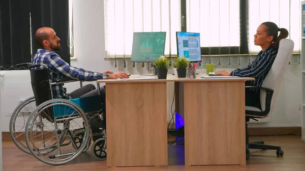 Femme d'affaires parlant avec un collègue paralysé — Photo