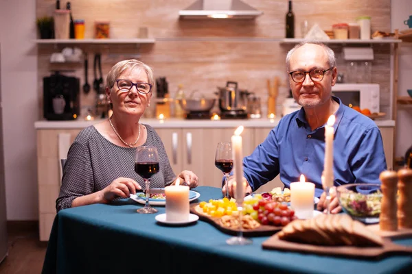 Fröhliches Paar in der Küche schaut in die Kamera — Stockfoto