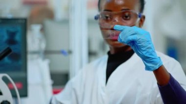 Siyah laboratuvar teknisyeni laboratuarda sonuçlar üzerinde deney yapıyor.