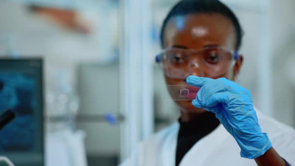 Primer plano del médico de química negra mirando la prueba de virus — Vídeos de Stock
