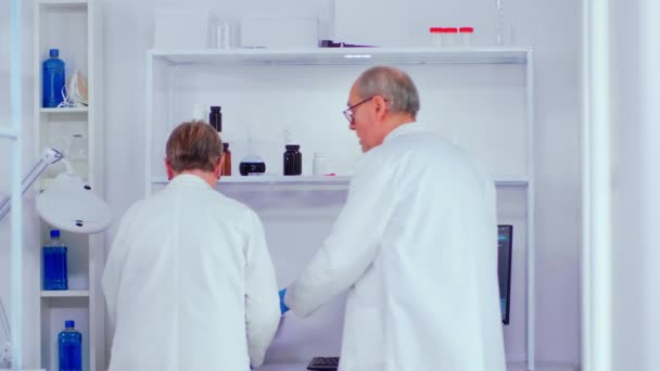 Modern laboratuvarda çalışan yaşlı biyokimyagerler — Stok video