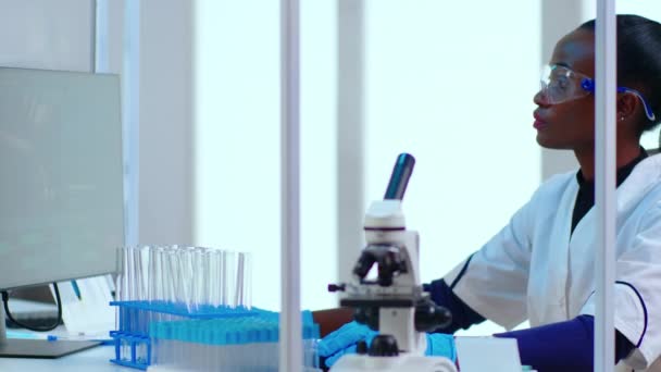 바이러스 의 개발을 확인하기 위해 pc 에 타자를 치는 흑인 여성 화학자의 사진 — 비디오