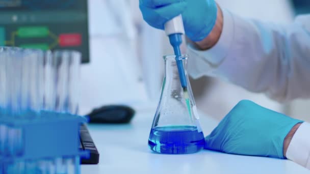 Close up of scientist filling test tube with liquid using pipette — Stock video