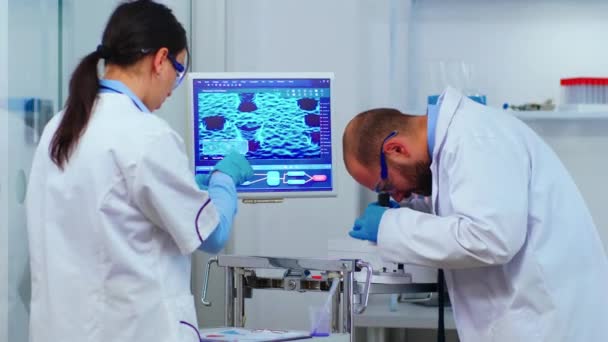 Equipo de biólogos experimentados trabajando en microscopios en laboratorio — Vídeos de Stock