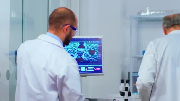 研究室で議論されているウイルスの進化を心配する科学者チーム — ストック動画