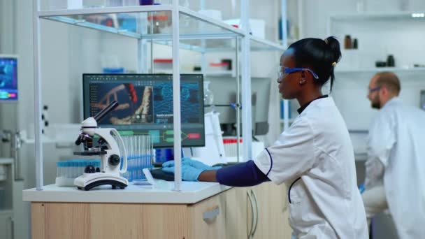 Africano médico mulher sorrindo para a câmera enquanto trabalhava em laboratório moderno equipado — Vídeo de Stock