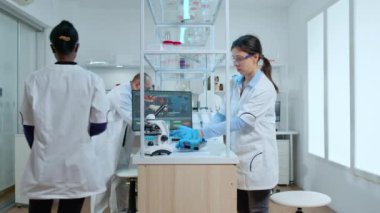 Aşıyı analiz eden bilim adamları mikroskop kullanarak laboratuvara girdiler.