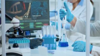 Mikro pipet kullanarak sıvı örneği test eden araştırmacıyı kapat