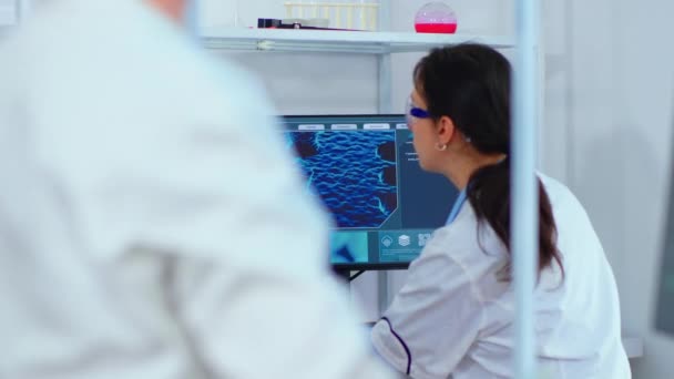 Wetenschappelijk verpleegkundige typen op computer in wetenschappelijk laboratorium — Stockvideo