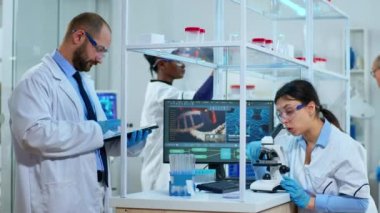 Mikroskop altında biyolojik araştırma yapan bilim adamlarından oluşan bir ekip.