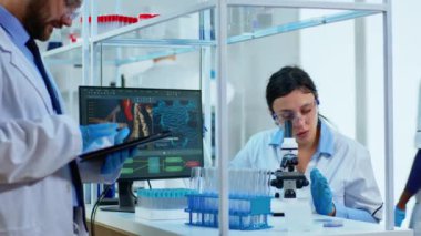 Tıbbi ekip bilim adamı dijital mikroskop altında DNA deneyleri yapıyor.