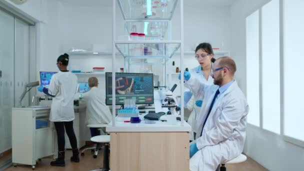 과학자 동료들은 튜브와 현미경을 사용하여 액체를 시험 한다 — 비디오