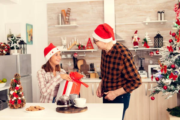 Nichte und Opa lächeln einander bei der Weihnachtsfeier zu — Stockfoto