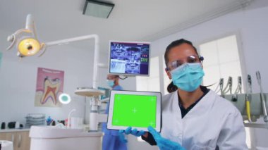 Hasta pov of dişçi analizing x-ray kullanarak yeşil ekranlı tablet