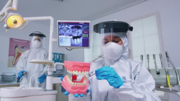 Pontos de vista do paciente do dentista em macacão mostrando acessório esqueleto — Vídeo de Stock