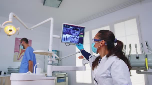 Patient kommt zum Zahnarzt und zeigt Röntgenbild auf Monitor — Stockvideo