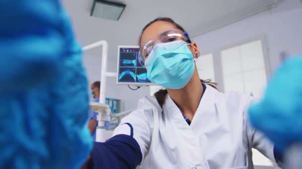 Patiëntstandpunt ten opzichte van tandarts in beschermende maskerbewaarmiddelen — Stockvideo