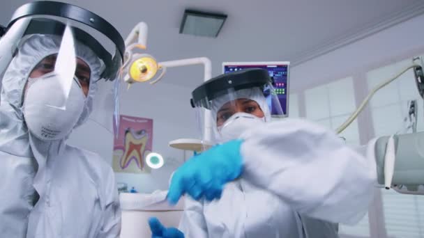 Squadra dentale in tuta appoggiata al paziente per lavorare sulle gengive del paziente — Video Stock